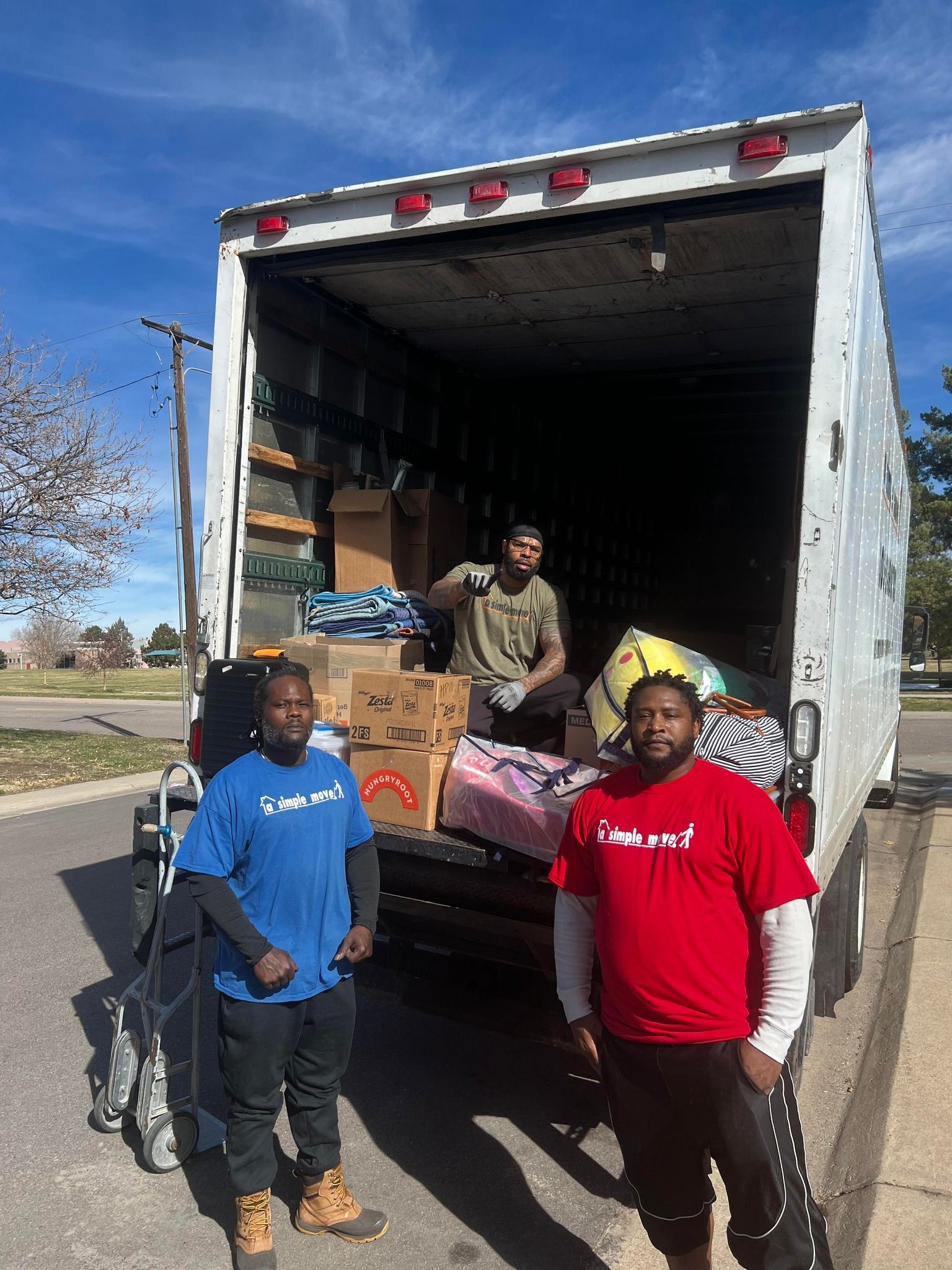 Two men are standing in front of a moving truck.