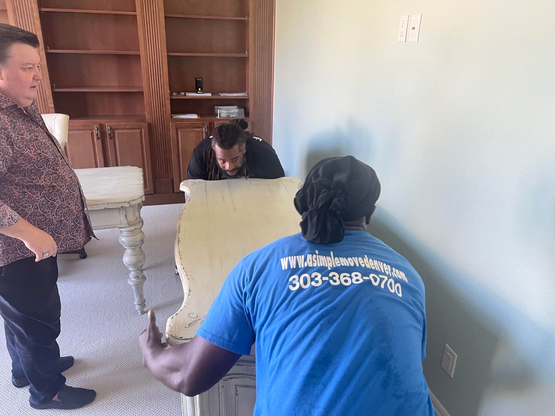 A man in a blue shirt has the number 303-368-0701 on his back