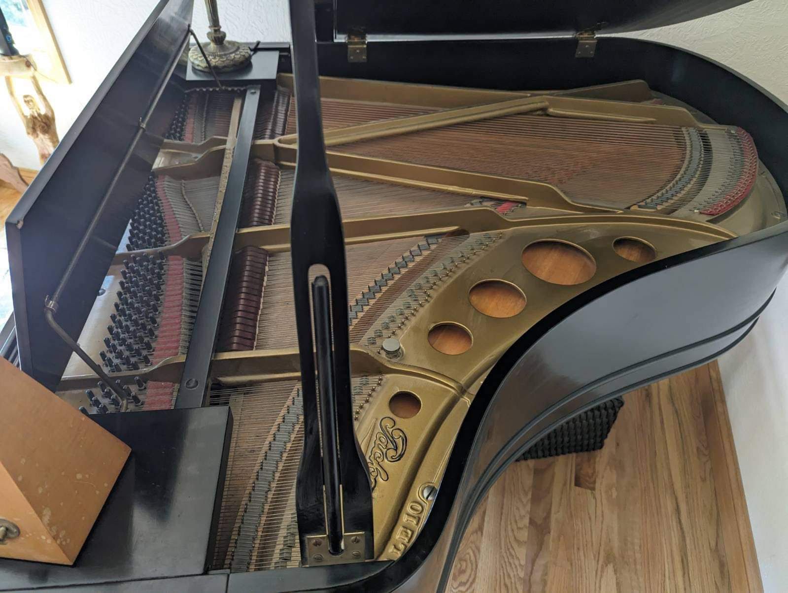 A black grand piano is sitting on a wooden floor