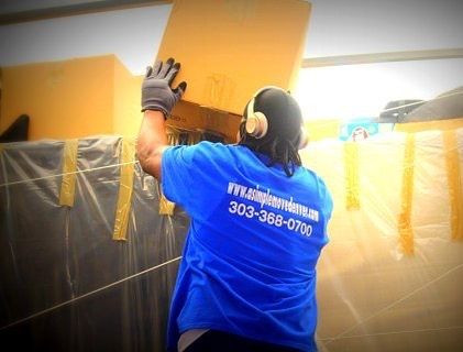 A man wearing headphones and a blue shirt with the number 303-368-0700 on the back