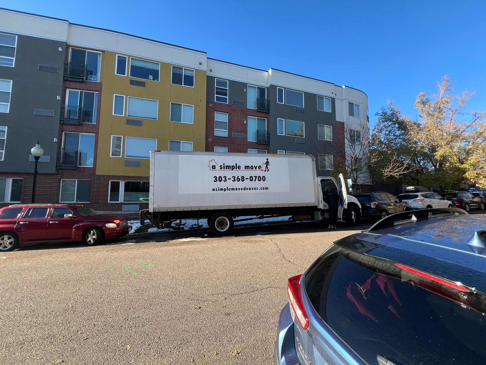 A white truck is parked in a parking lot in front of a building.