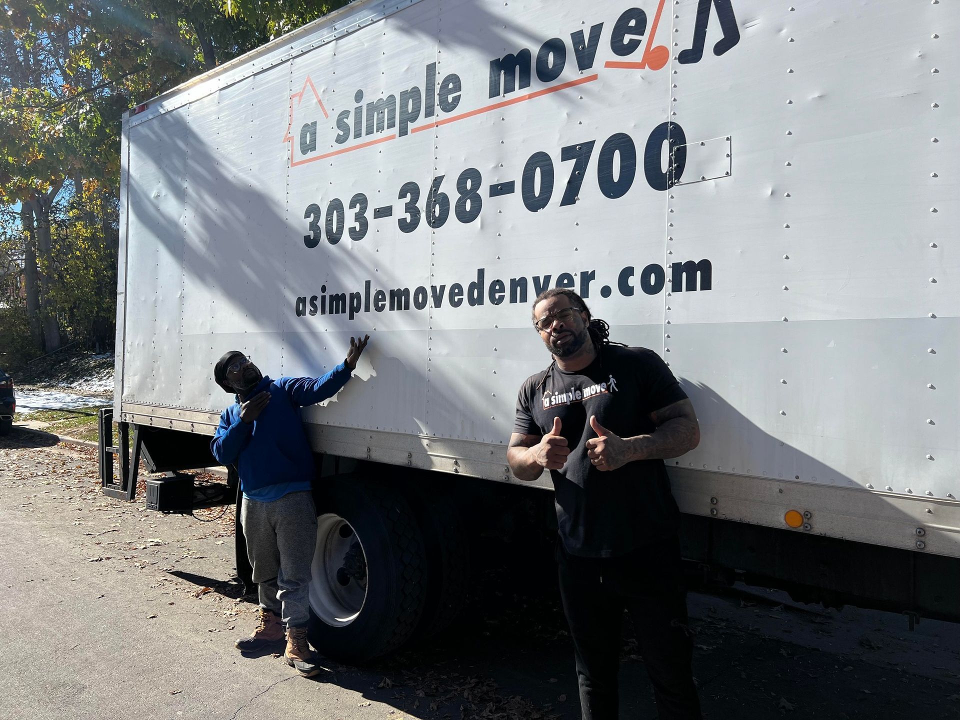 Two men standing in front of a simple moves truck