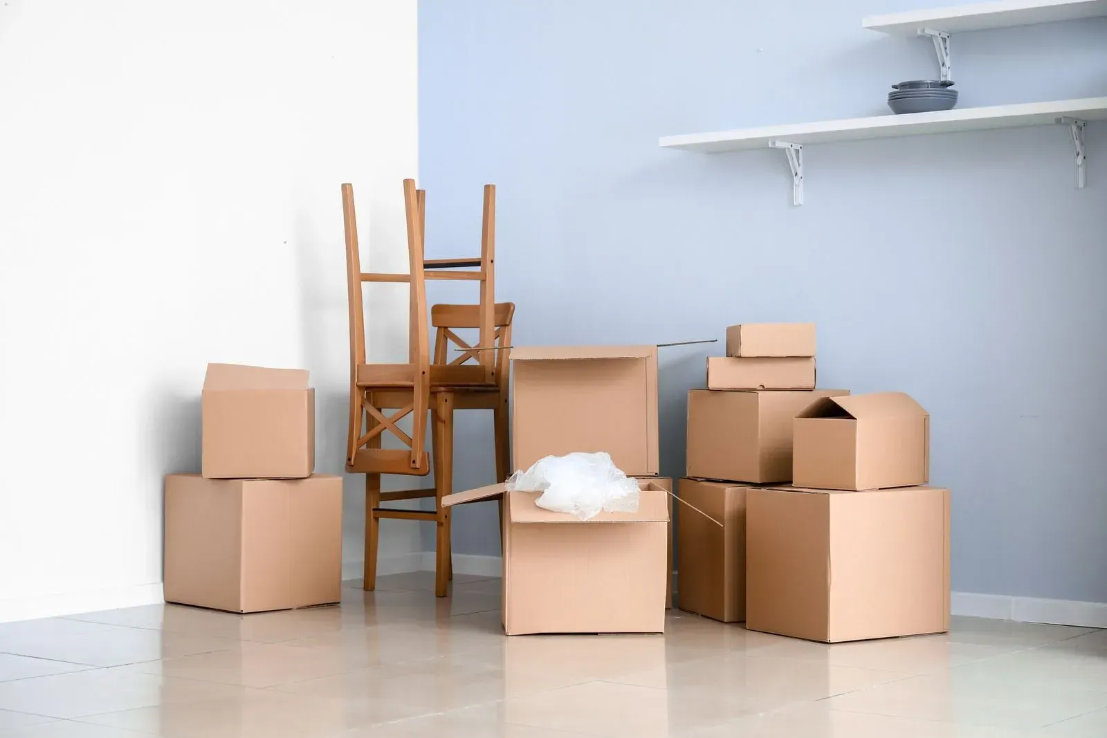 A room filled with cardboard boxes and a chair.