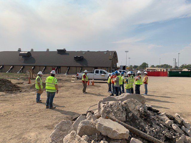 A group of construction workers are standing in front of a building.