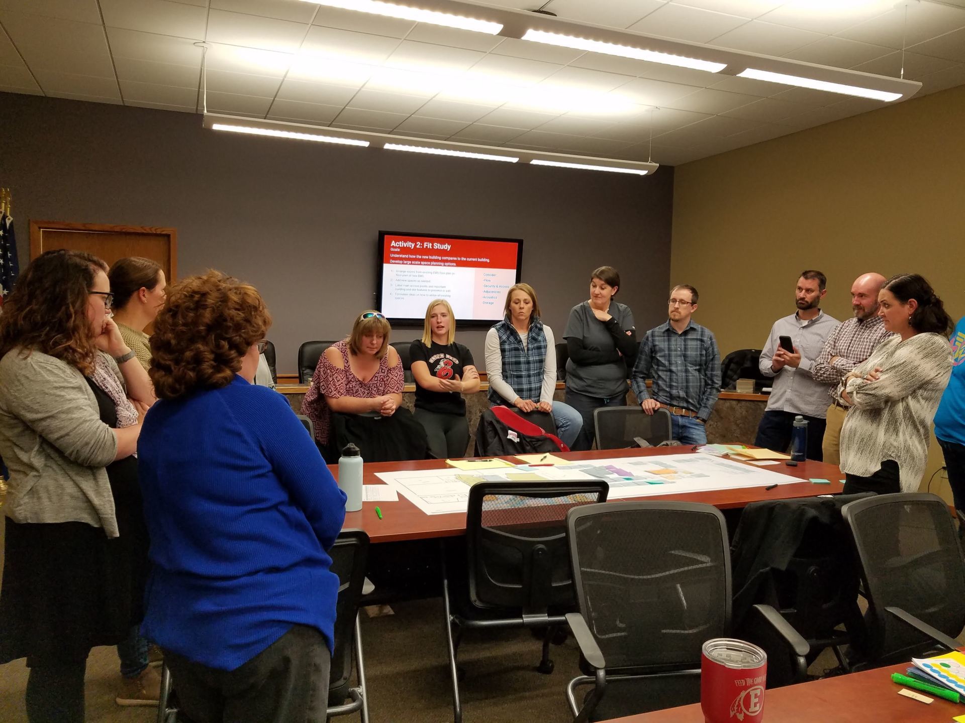 A group of people are sitting around a table in a conference room.