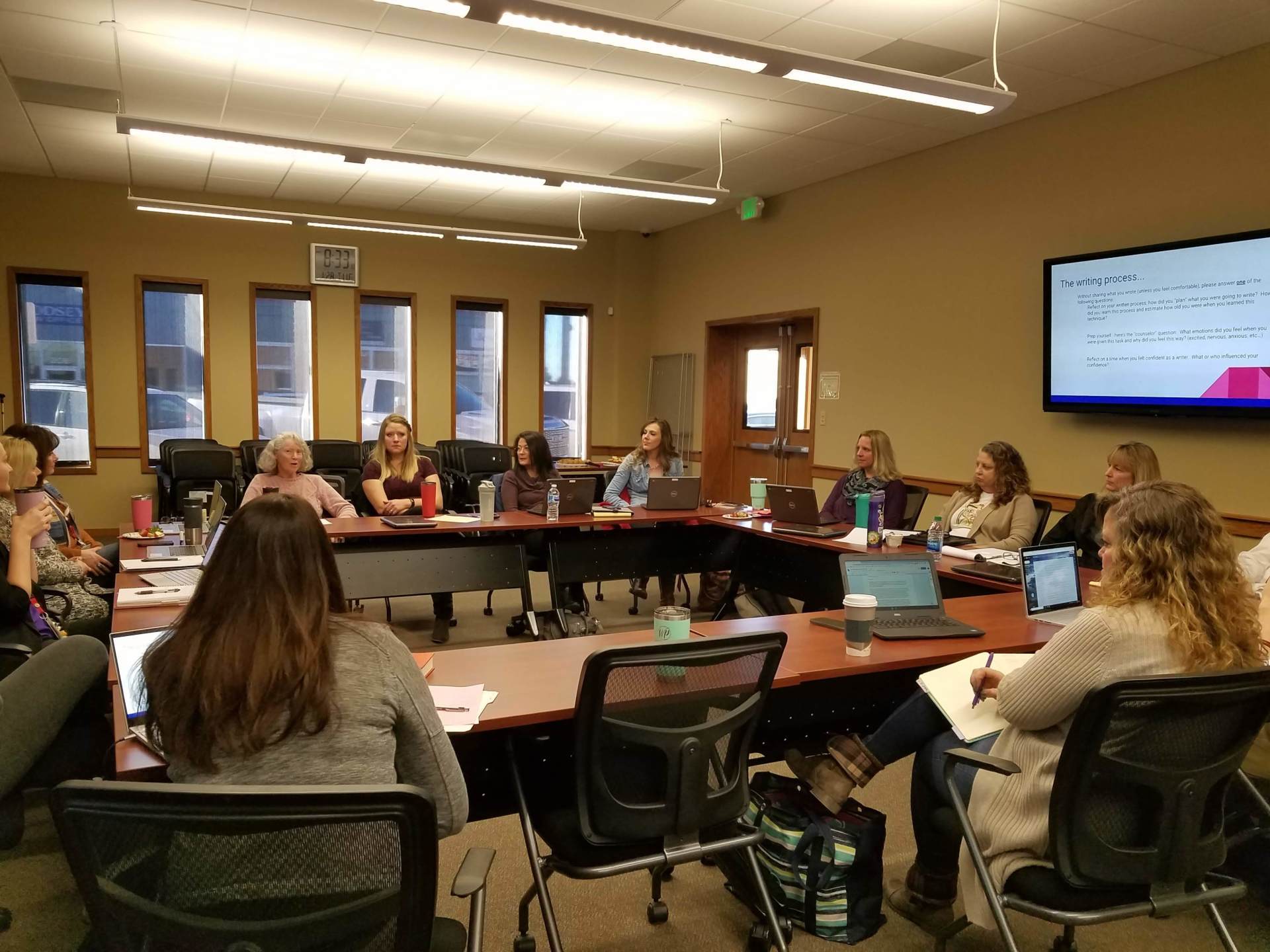 A group of people are sitting around a table in a conference room.