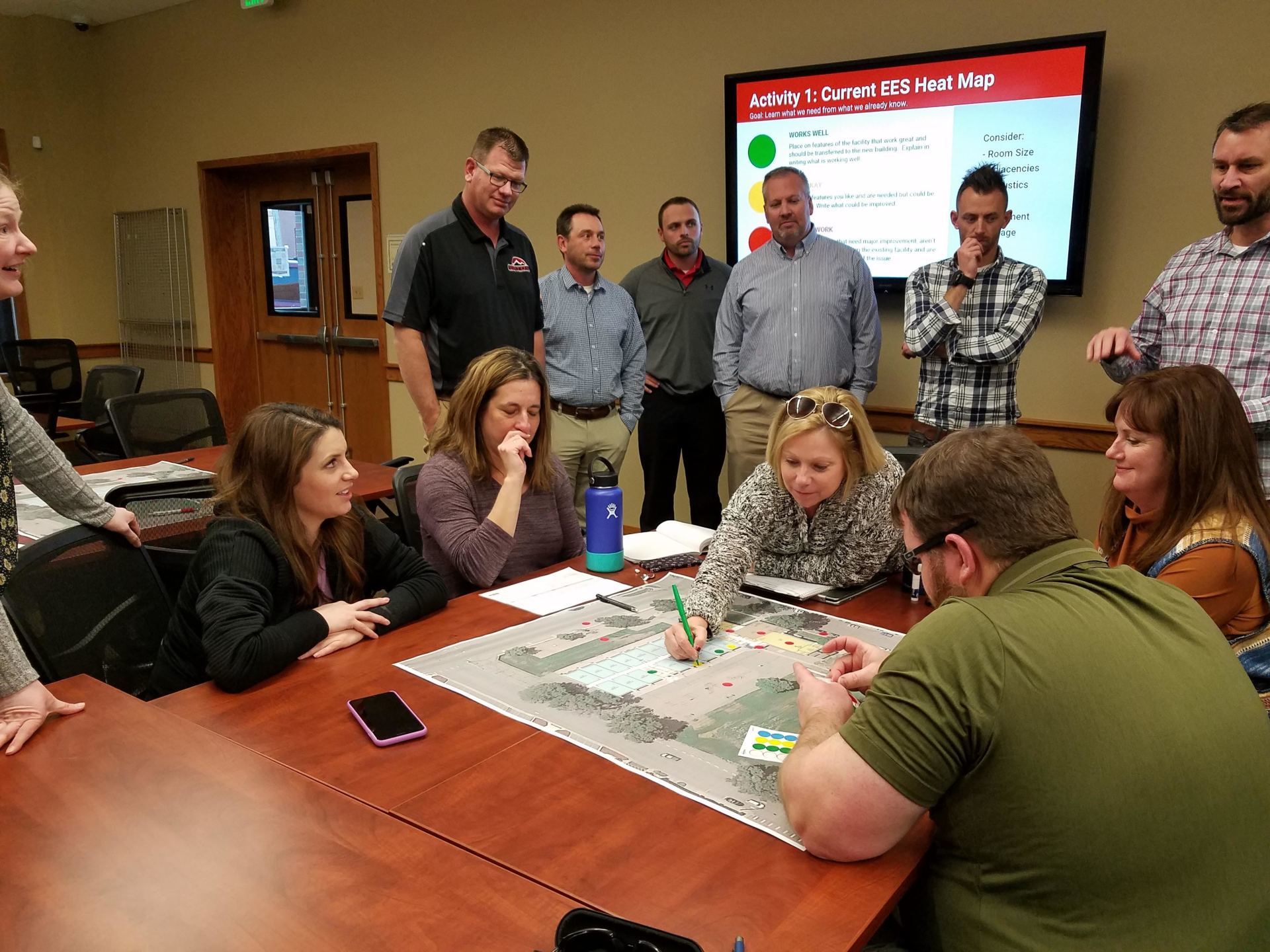 A group of people are sitting around a table with a map on it.