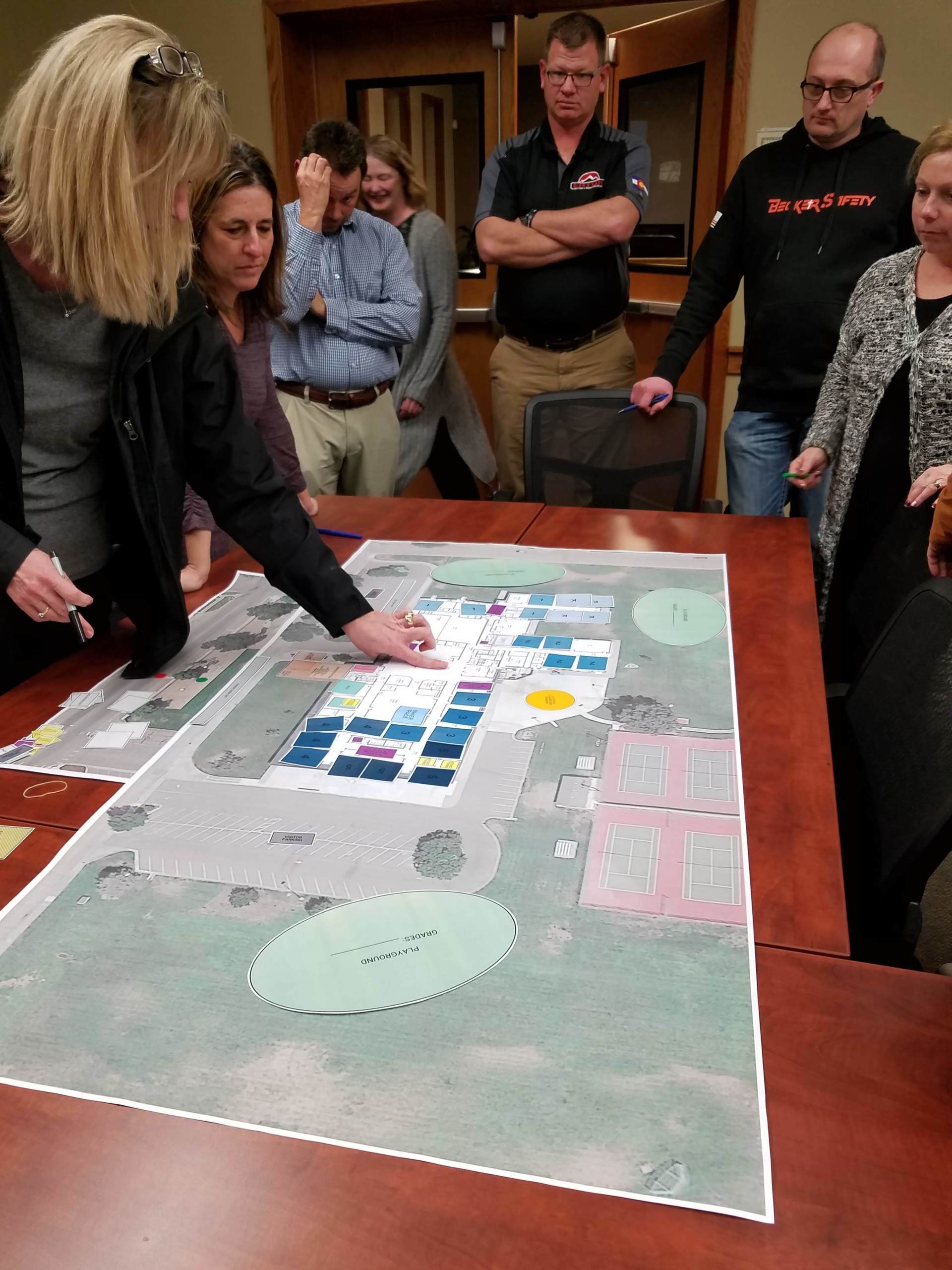 A group of people are looking at a map on a table.