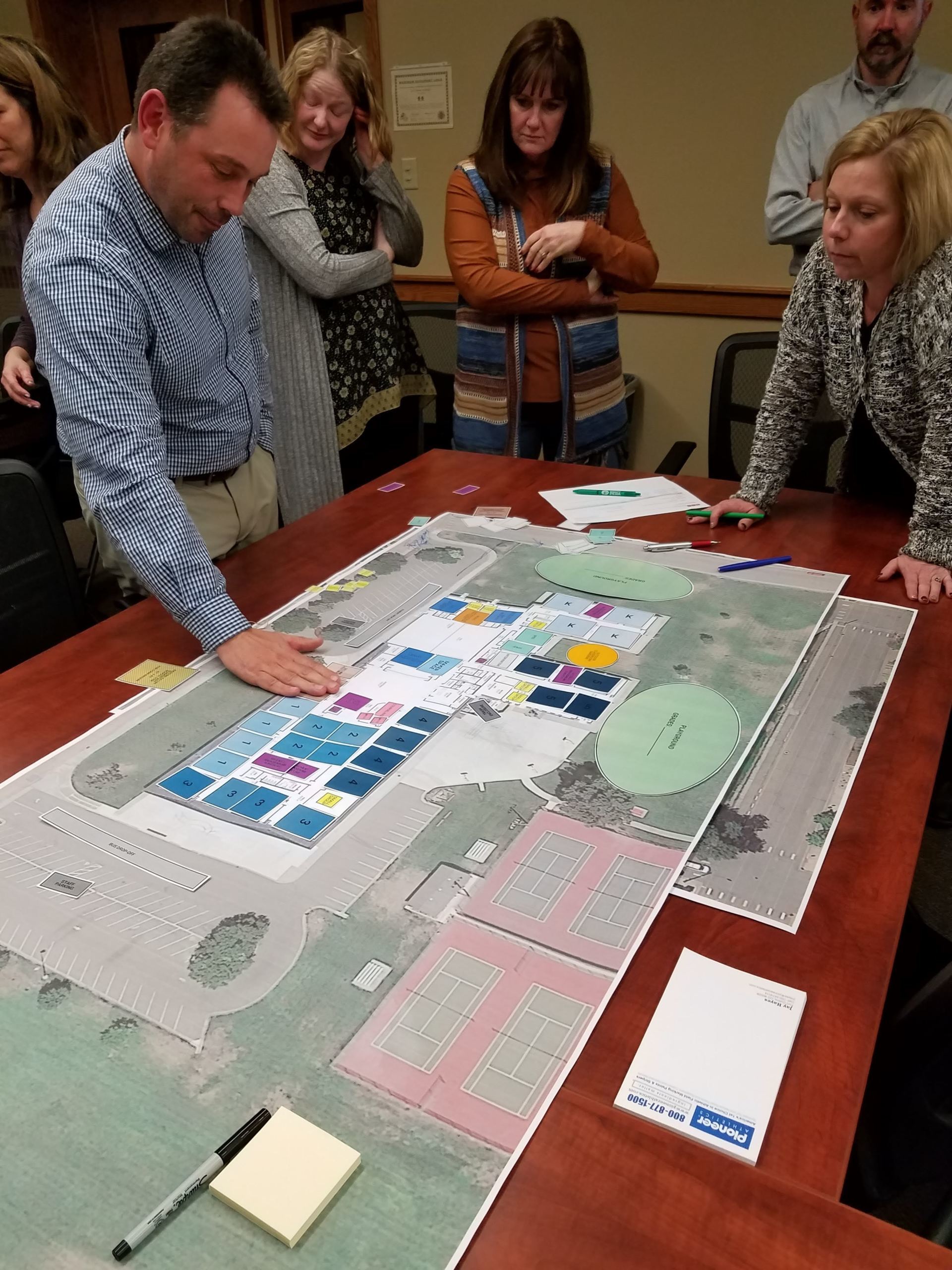 A group of people are looking at a map on a table