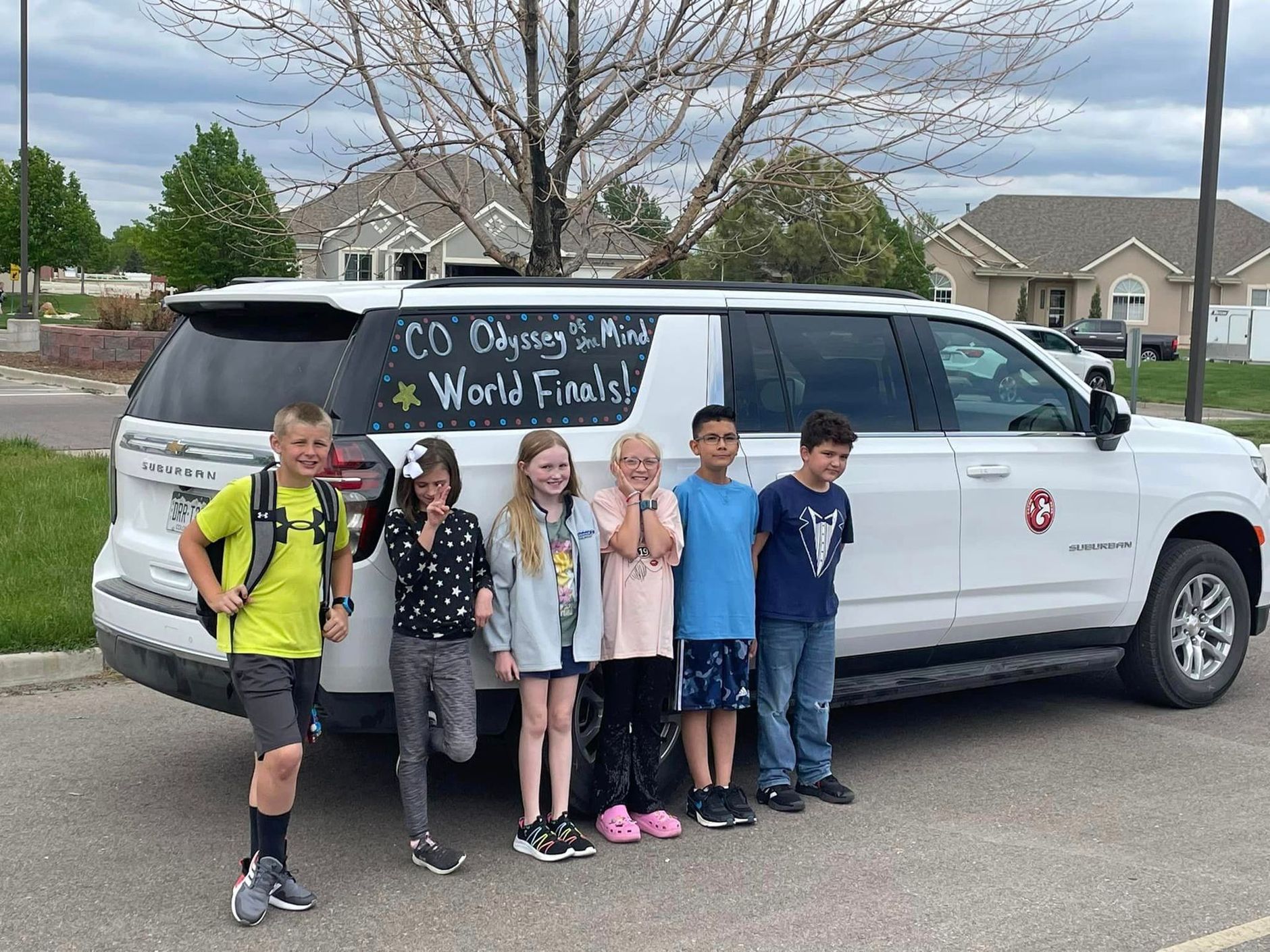 BEES Odyssey of the Mind team standing in front of a car. 