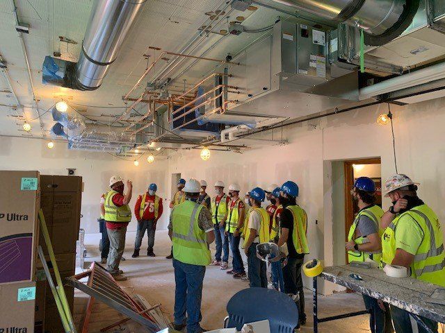 A group of construction workers are standing in a room.