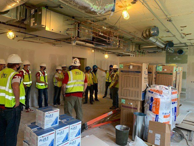 A group of construction workers are standing in a room.