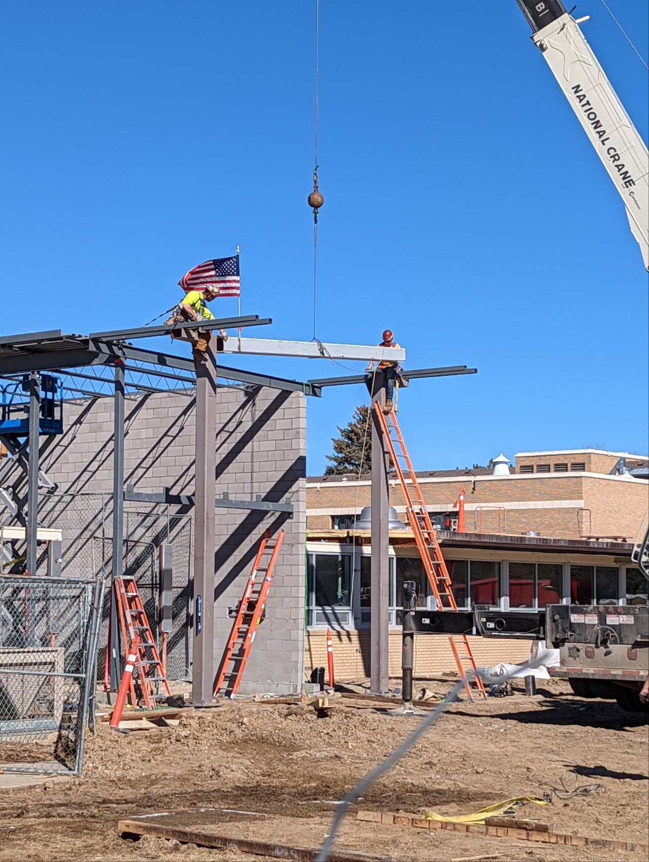 A crane is lifting a beam in a construction site.
