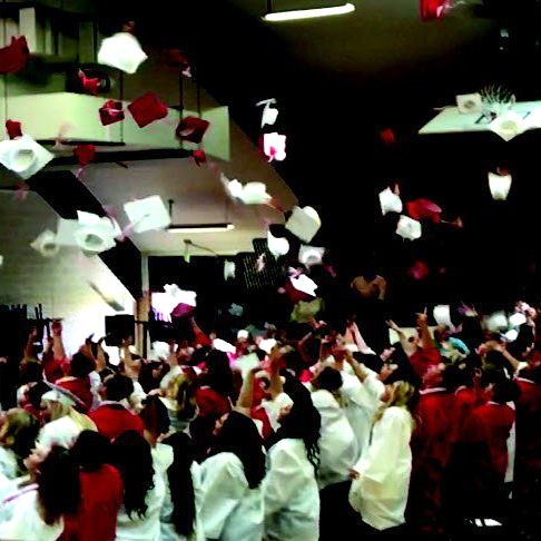 A large group of people throwing papers in the air