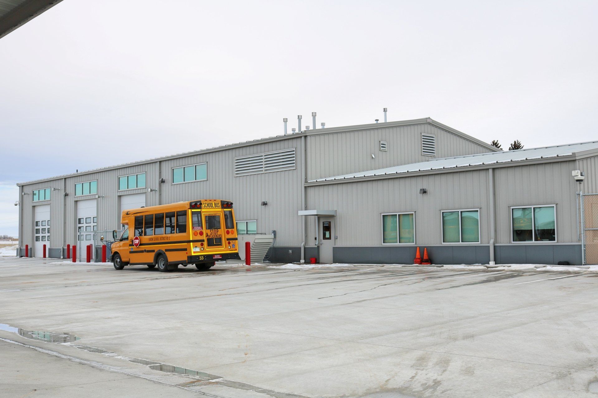 A yellow school bus is parked in front of a building