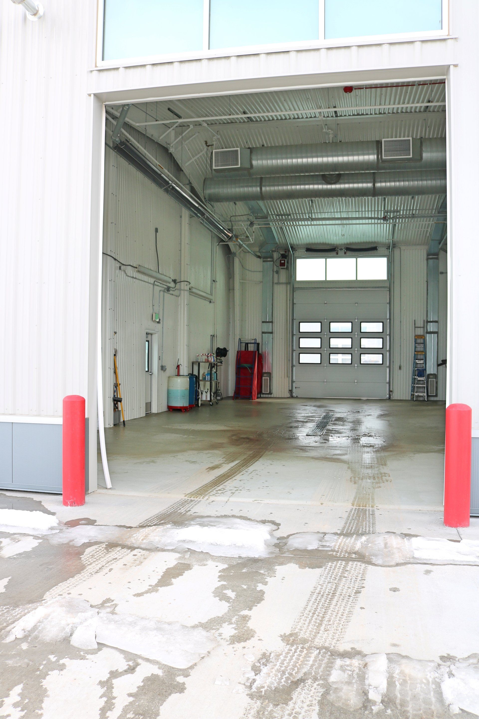 A large empty warehouse with a large garage door open.