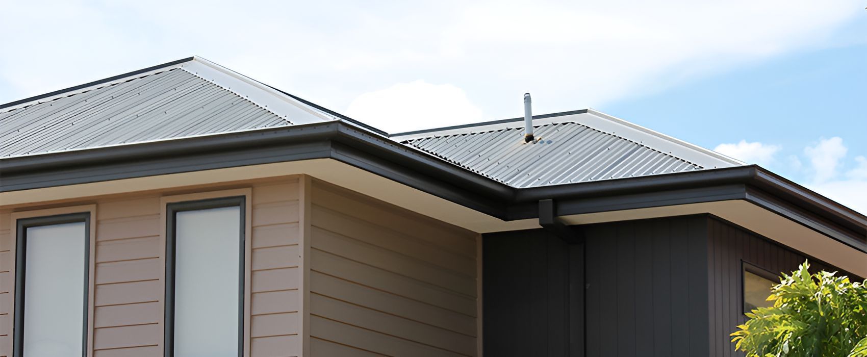 A House With a Metal Roof and Gutters on a Sunny Day — Munro Building Group In Brisbane, QLD