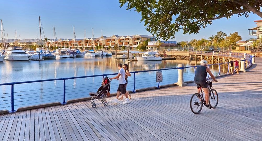 A Man Riding A Bike And View Place — Munro Building Group In Cleveland, QLD