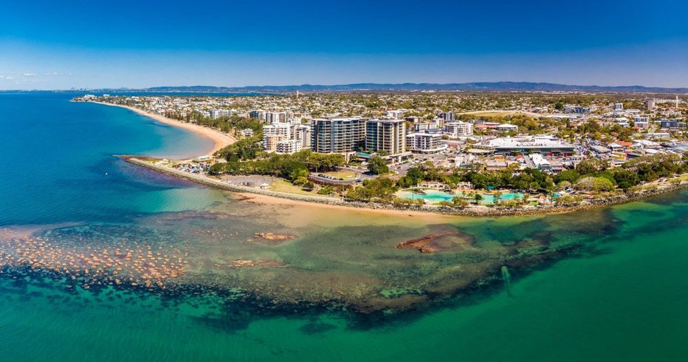 An Aerial View Of A Beach With A City In The Background — Munro Building Group In Redcliffe, QLD