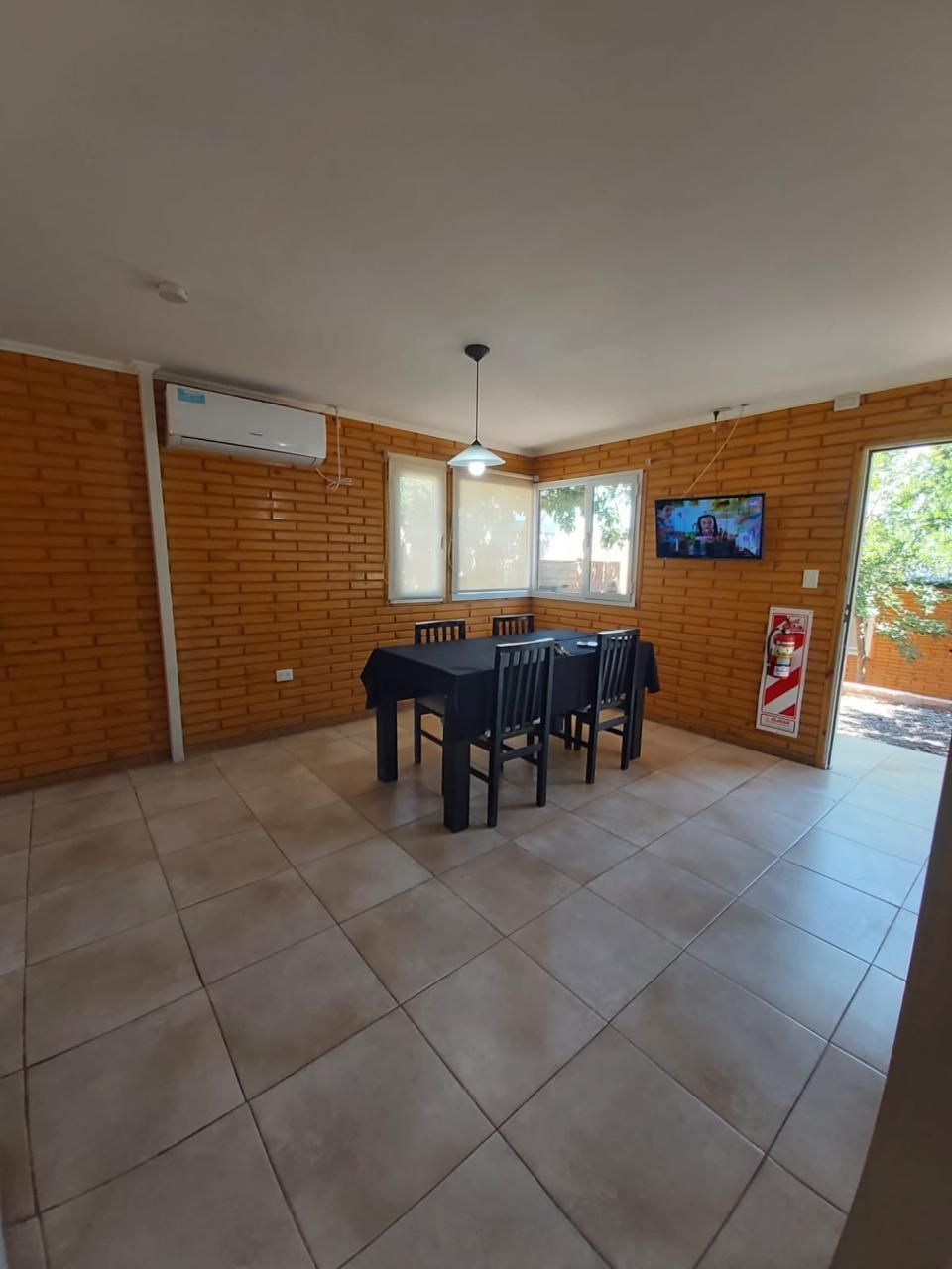 Un comedor con mesa y sillas y un televisor.