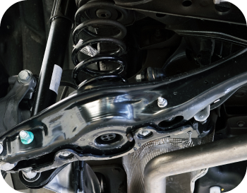 A close up of the underside of a car 's suspension system. | NRH Automotive