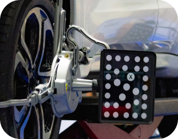 A car wheel is being adjusted by a machine with a x on it | NRH Automotive