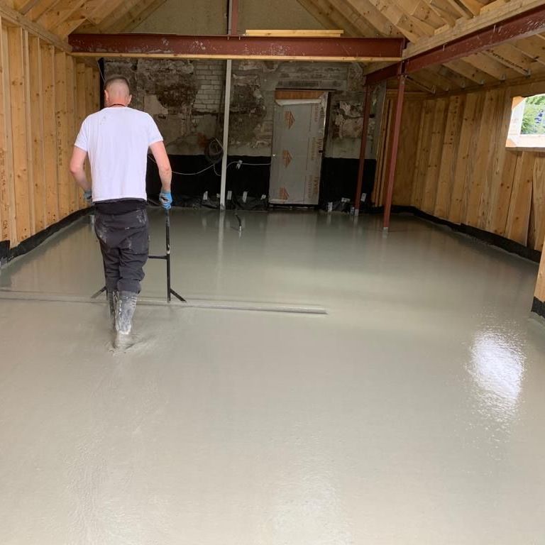 One of City Flow Screed's professionals levelling a newly screeded floor.