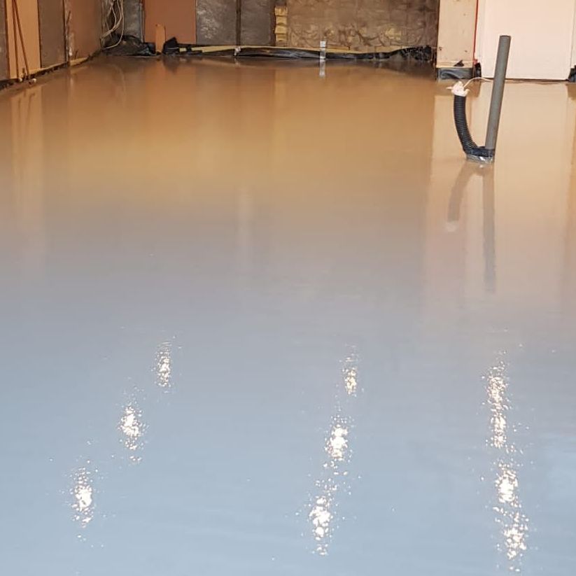 A freshly laid screed floor, still wet and requires drying.