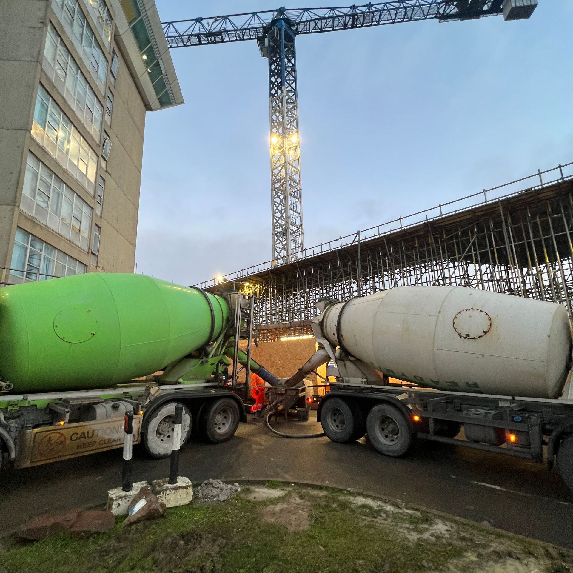 Two of our screed delivery trucks pumping screed into a commercial installation.