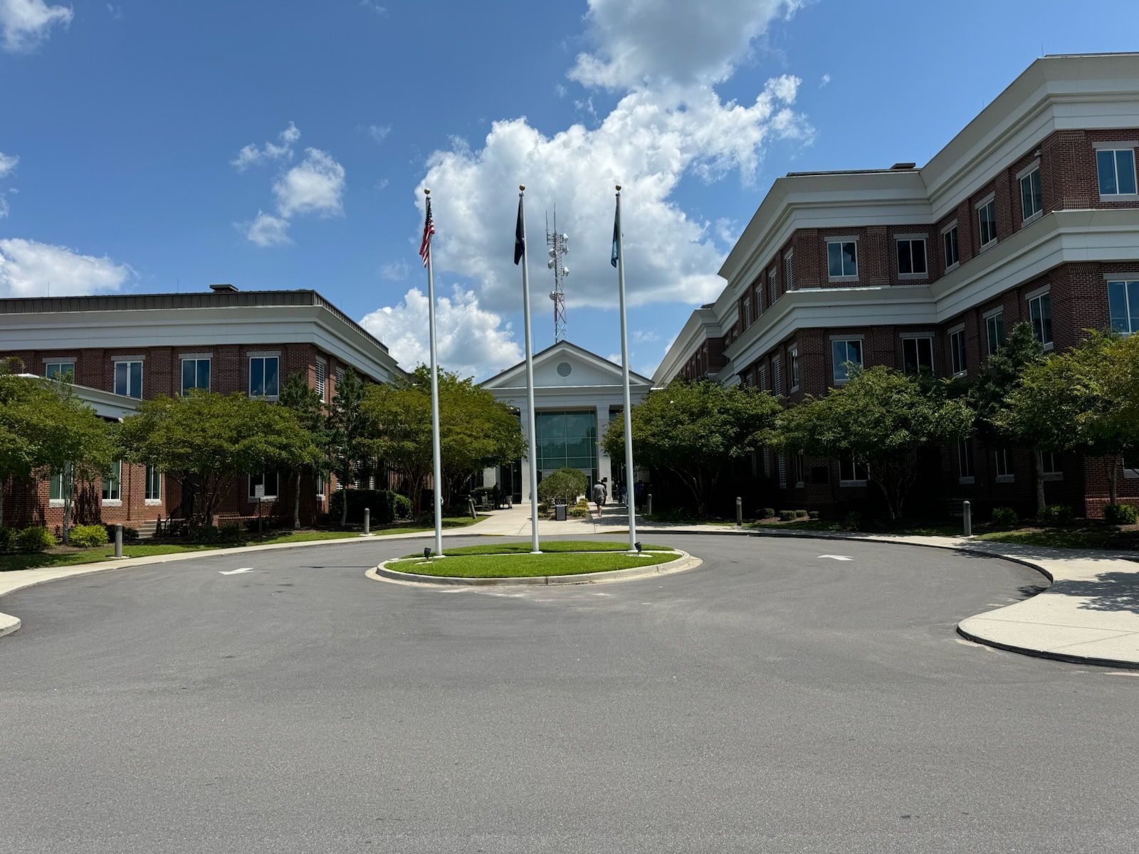 A large brick building with a circular driveway in front of it.