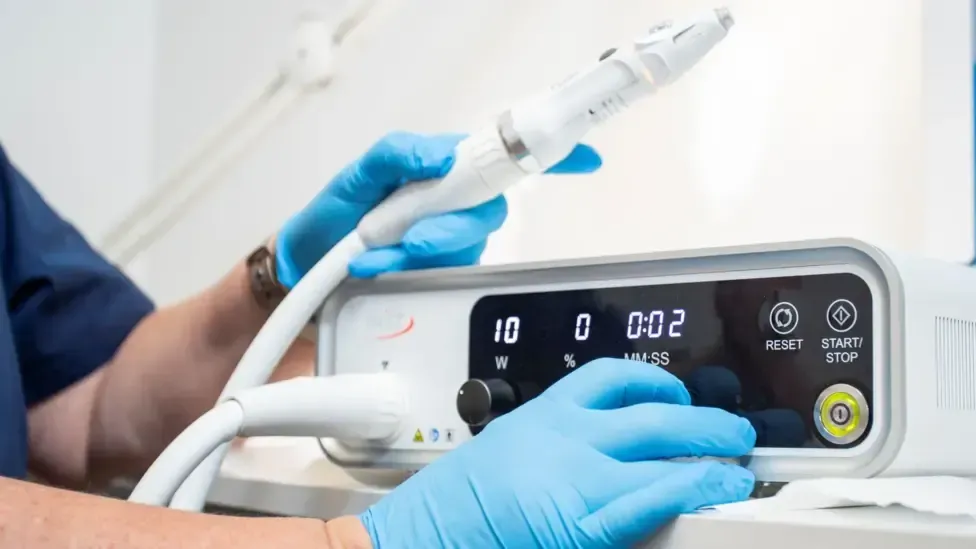 Toetal footcare Podiatrists, Cardiff & Pontypridd A person wearing blue gloves is using a machine.