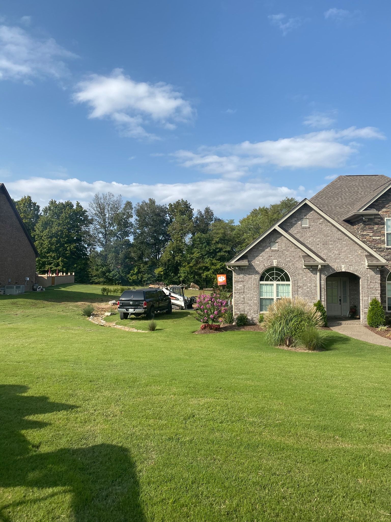 A large brick house with a large lawn in front of it.