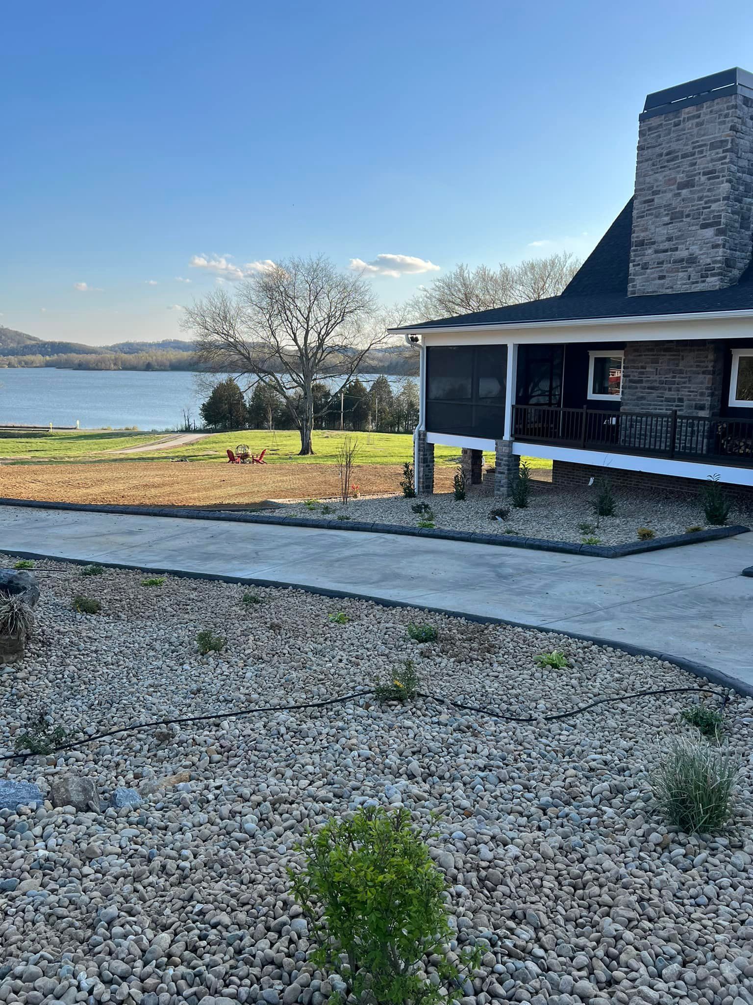 A house with a screened in porch and a view of a lake.