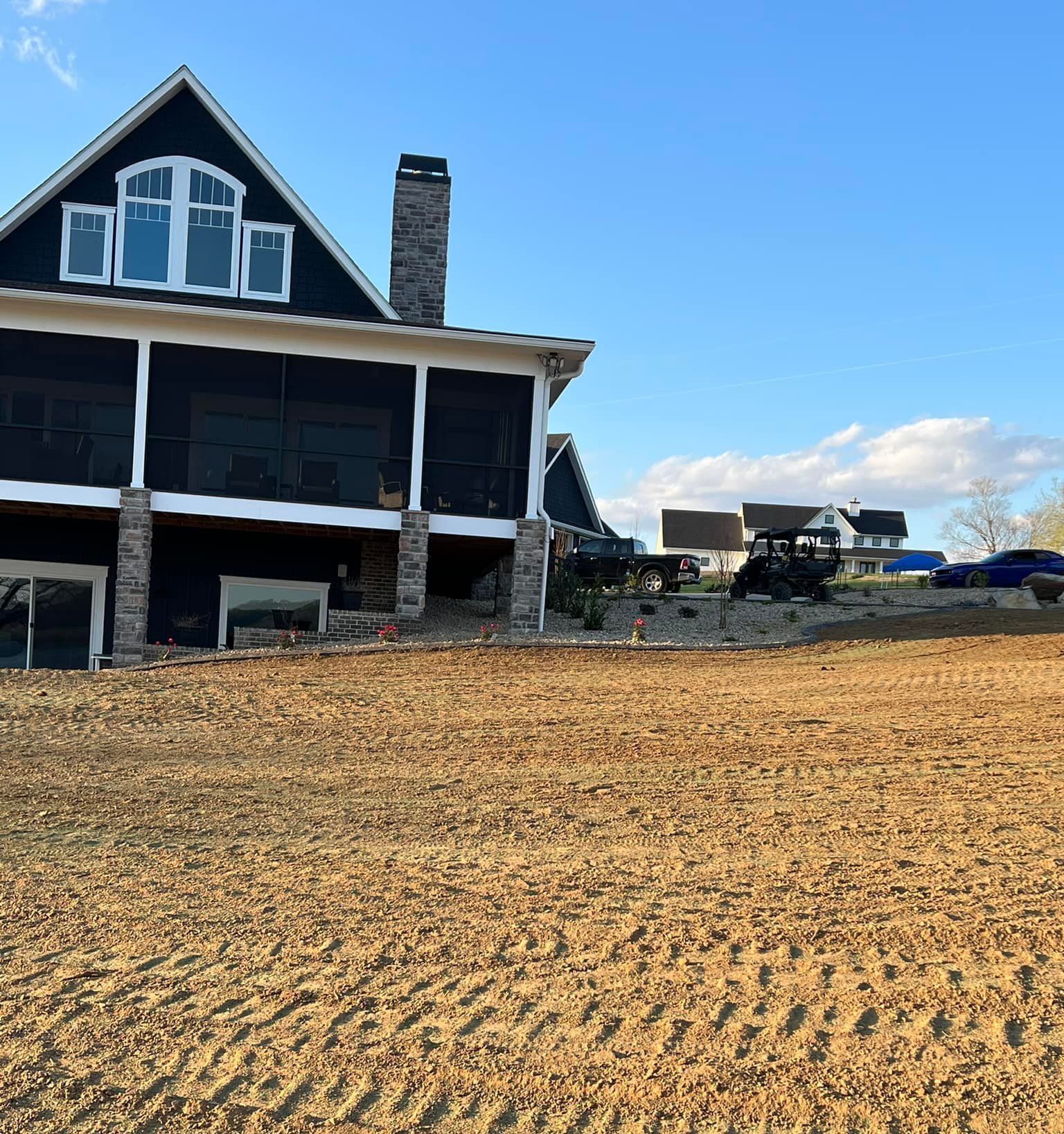 A large house is sitting on top of a dirt field.