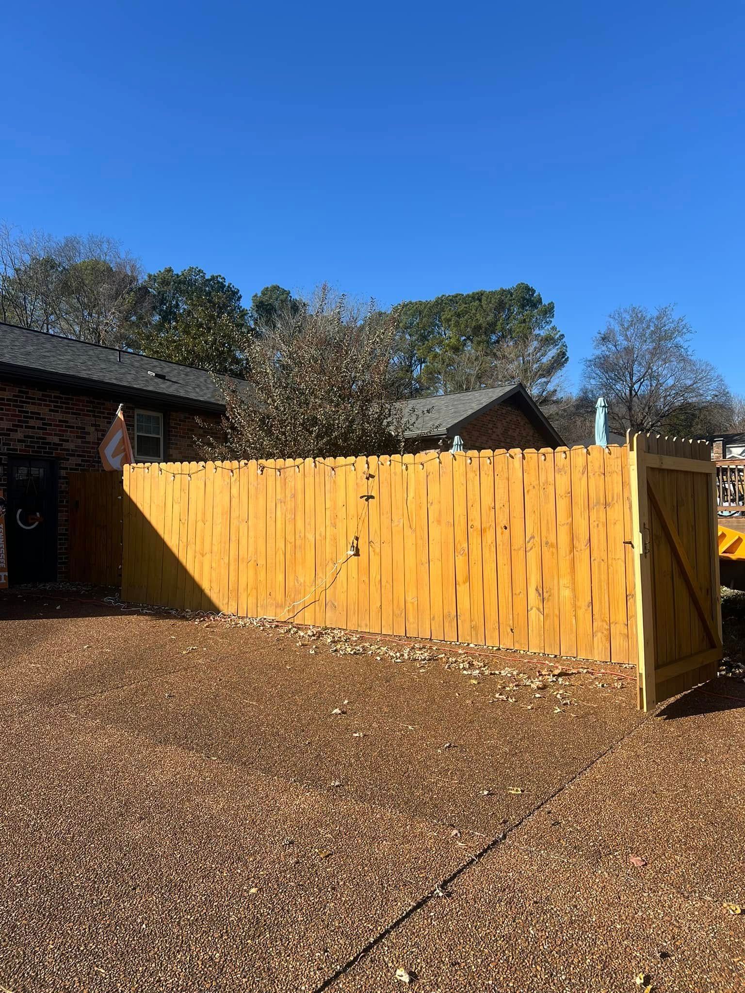 A yellow wooden fence is sitting in front of a house.