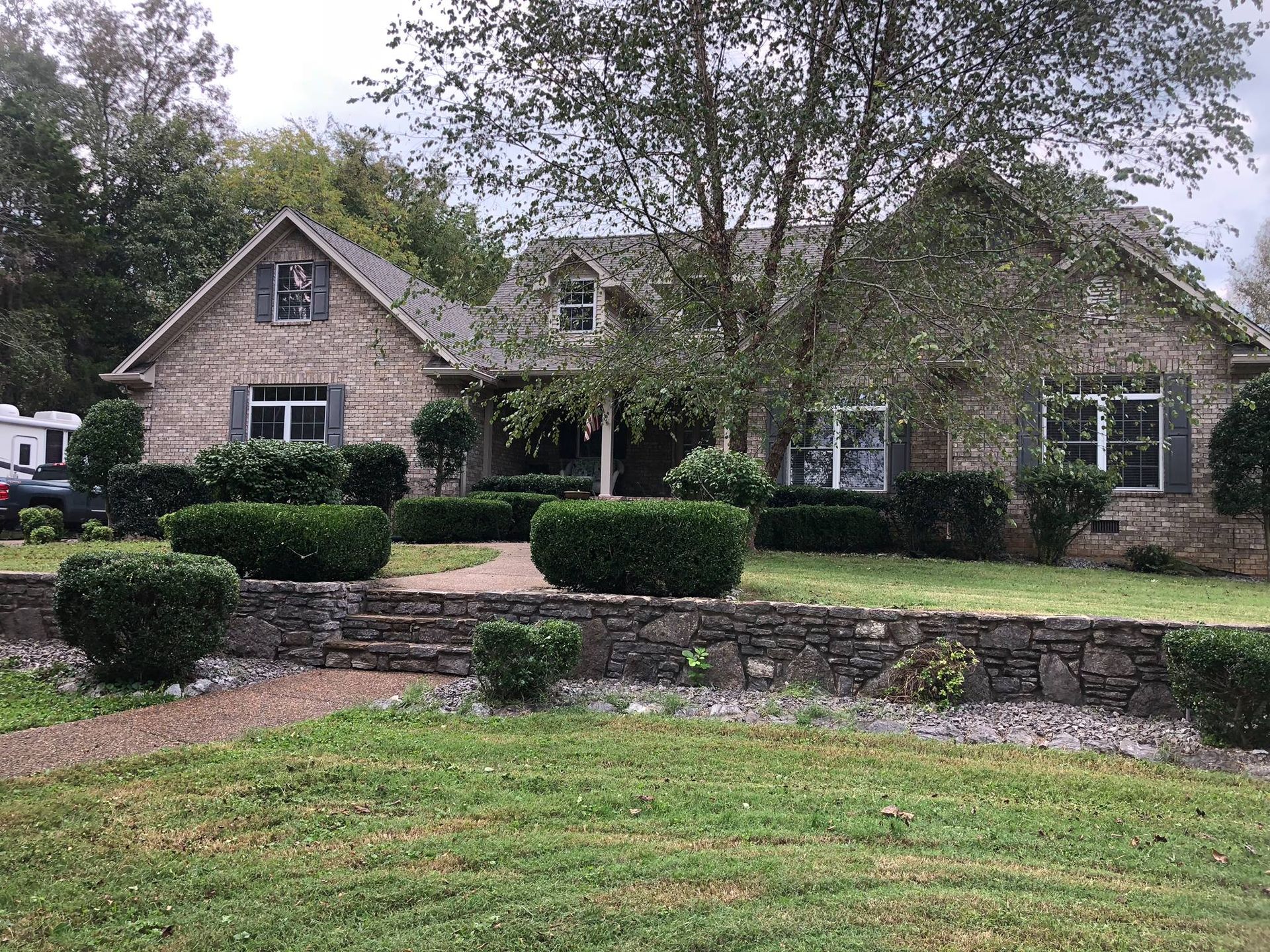 A large brick house with a large lawn in front of it.