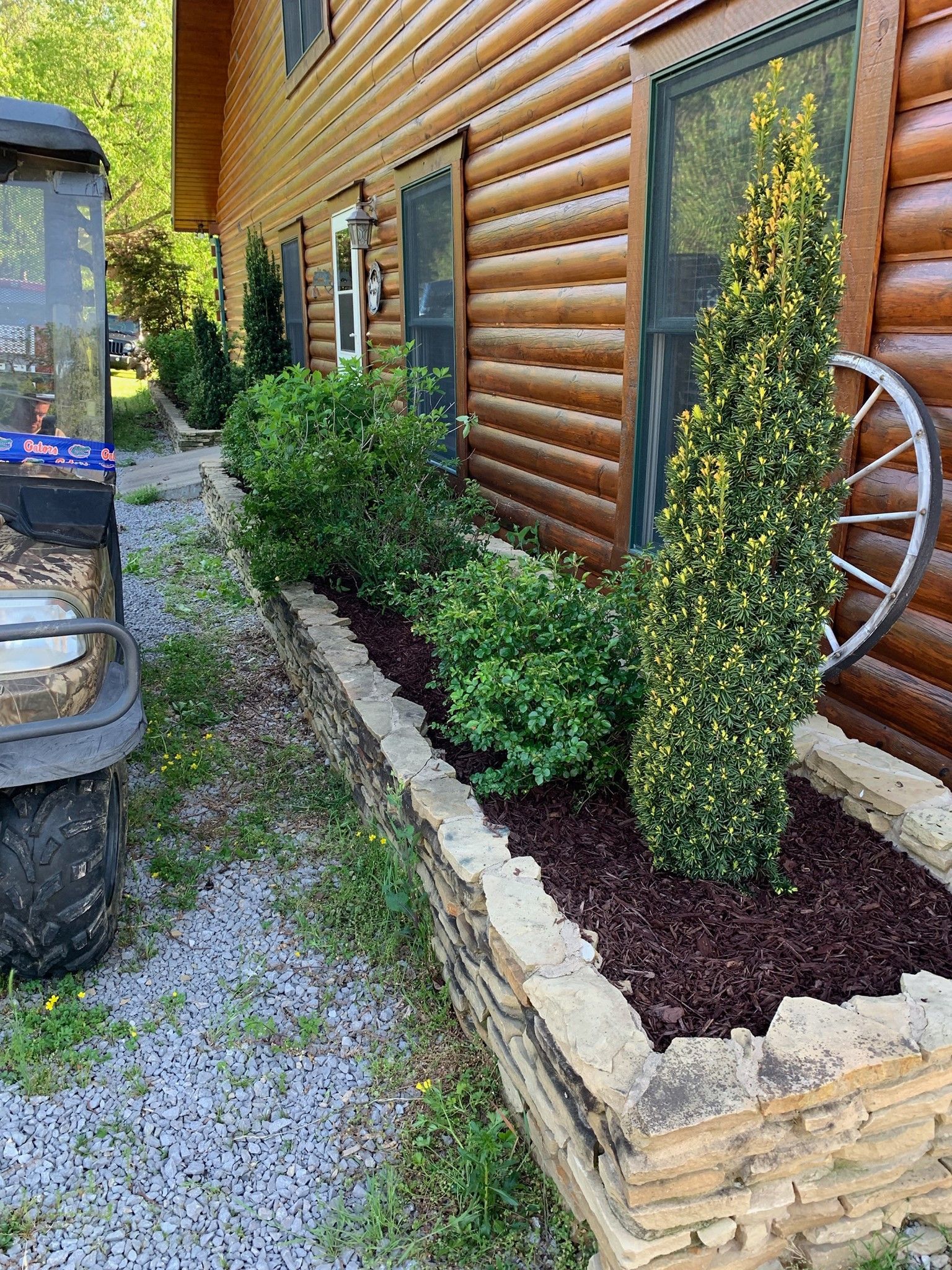 A log cabin with a wagon wheel on the side of it.
