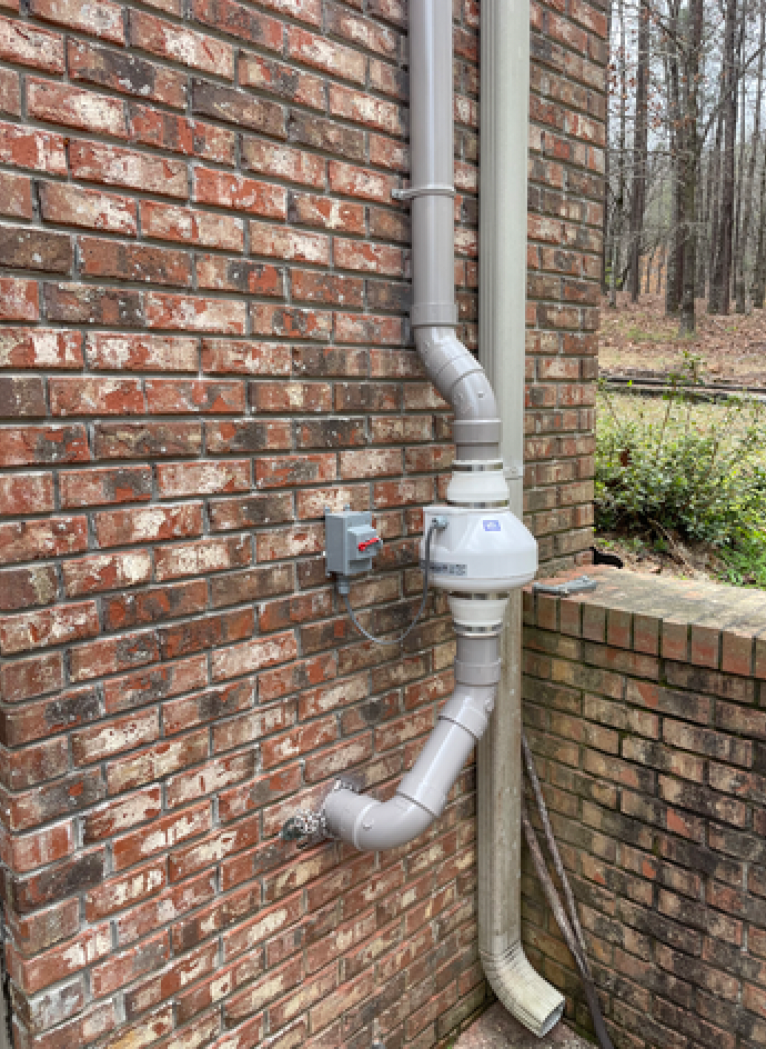A Brick Wall with A Drain Pipe Attached to It | Birmingham, AL | Cardinal Construction