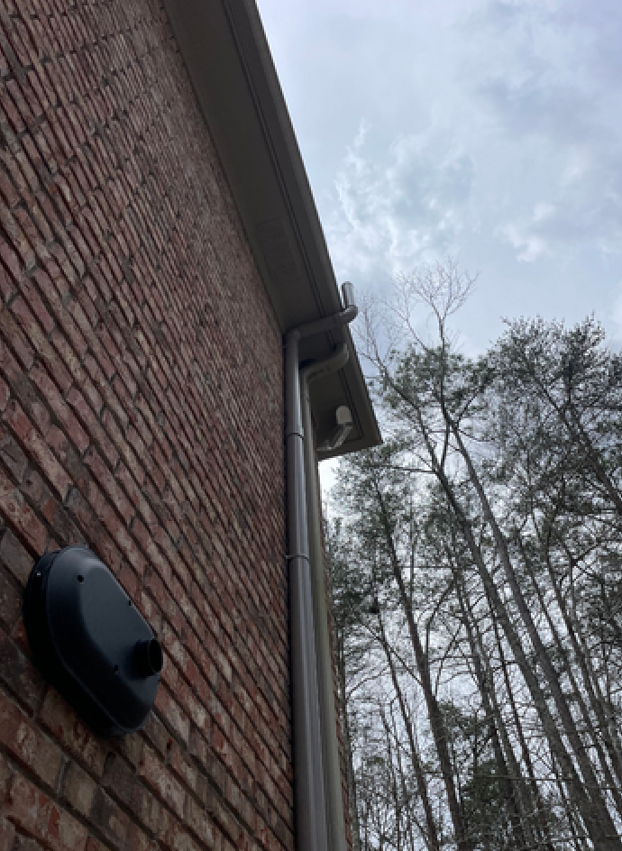 A Brick Building with A Gutter on The Side of It and Trees in The Background | Birmingham, AL | Cardinal Construction