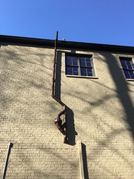 A Brick Building with A Drainpipe on The Side of It | Birmingham, AL | Cardinal Construction