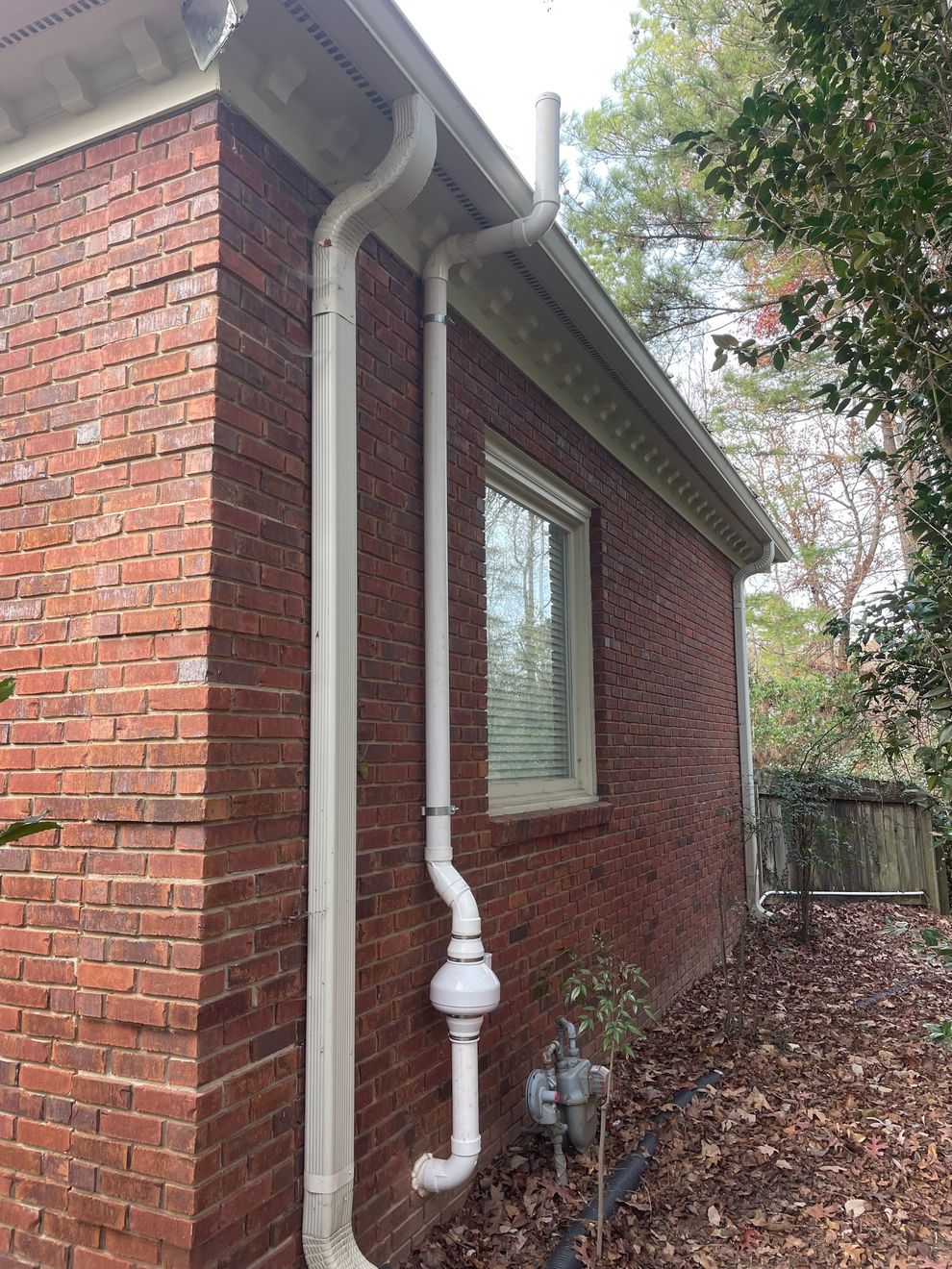 A White Pipe Is Attached to The Side of A Brick House | Birmingham, AL | Cardinal Construction