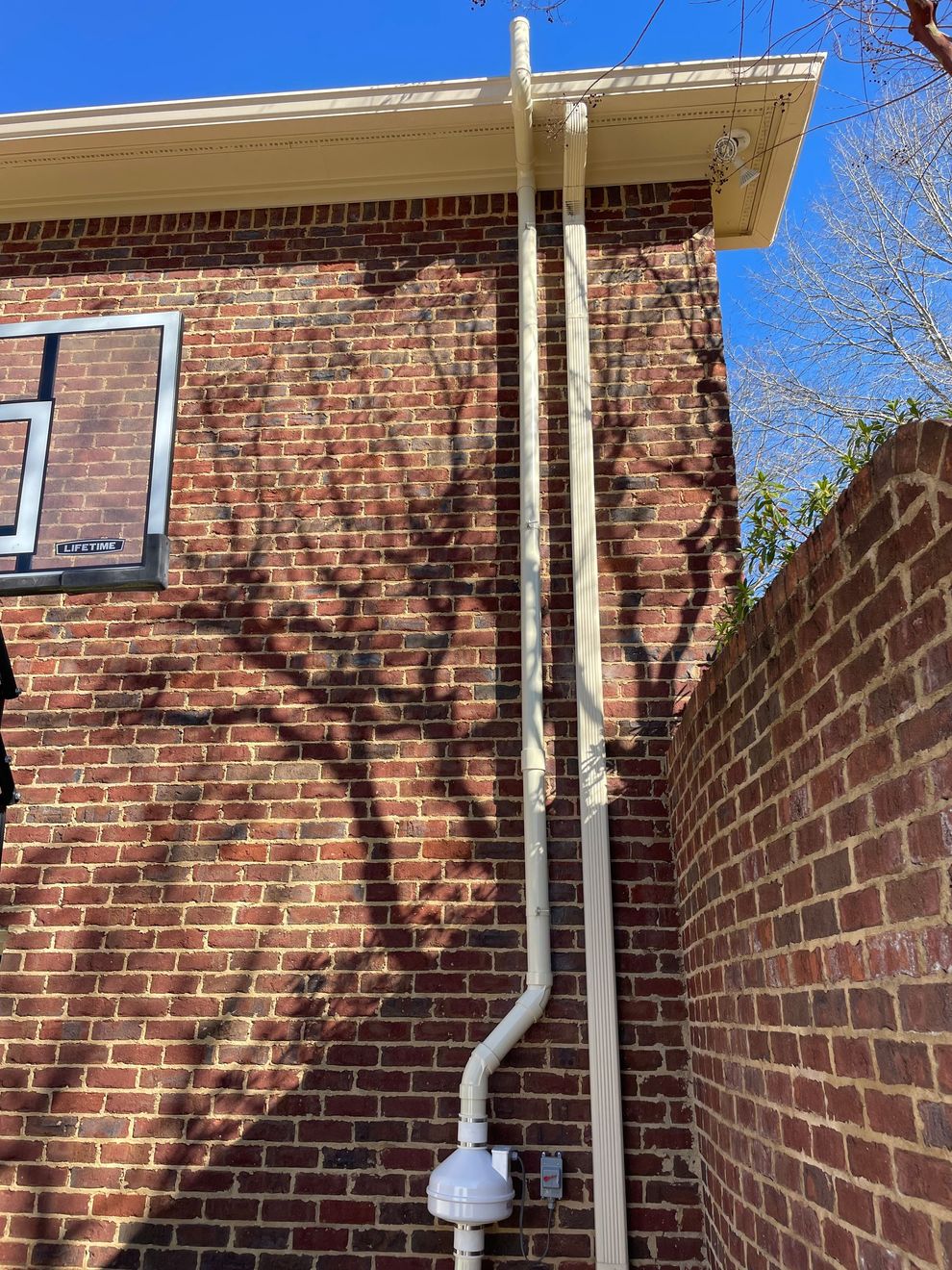 A White Pipe Is Attached to The Side of A Brick Building | Birmingham, AL | Cardinal Construction