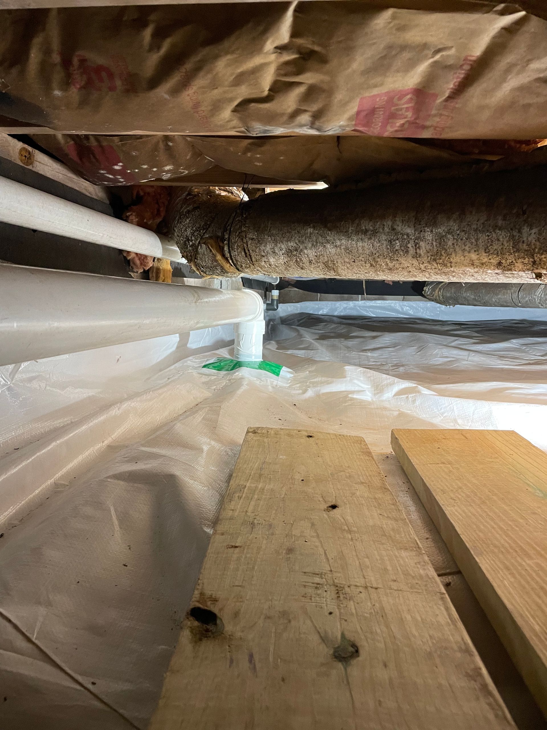 A Wooden Plank Is Sitting Next to A Pipe in A Basement | Birmingham, AL | Cardinal Construction
