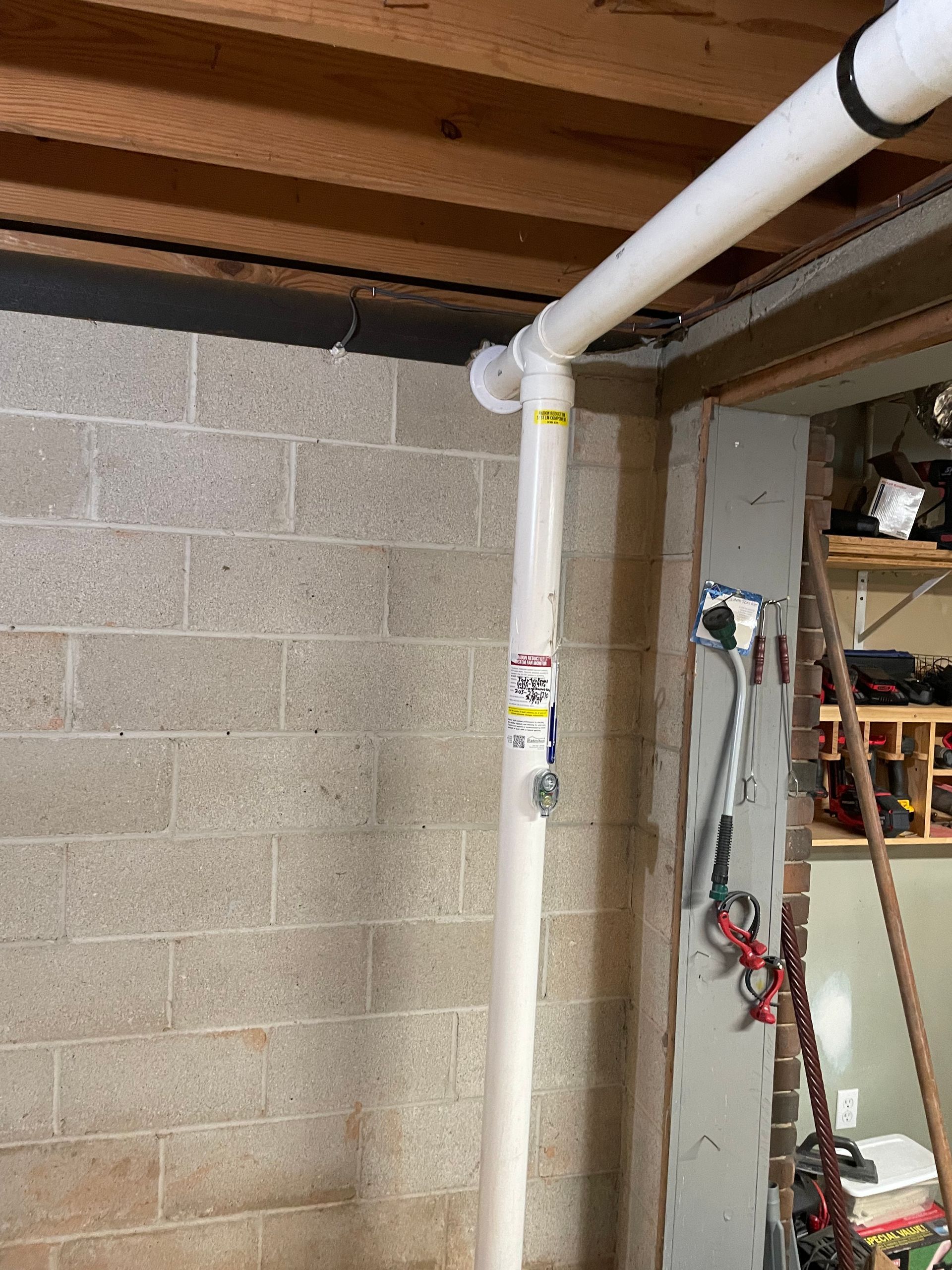 A White Pipe Is Hanging from The Ceiling in A Basement | Birmingham, AL | Cardinal Construction