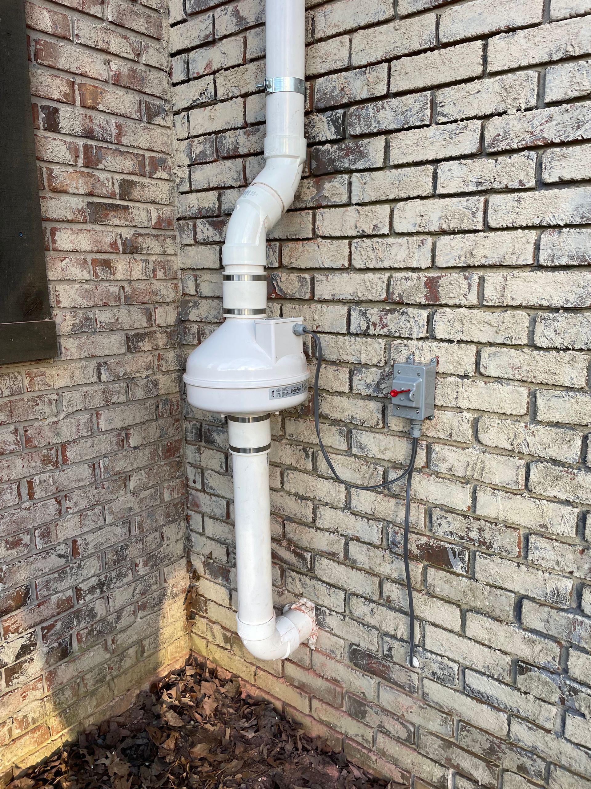 A White Pipe Is Attached to A Brick Wall | Birmingham, AL | Cardinal Construction