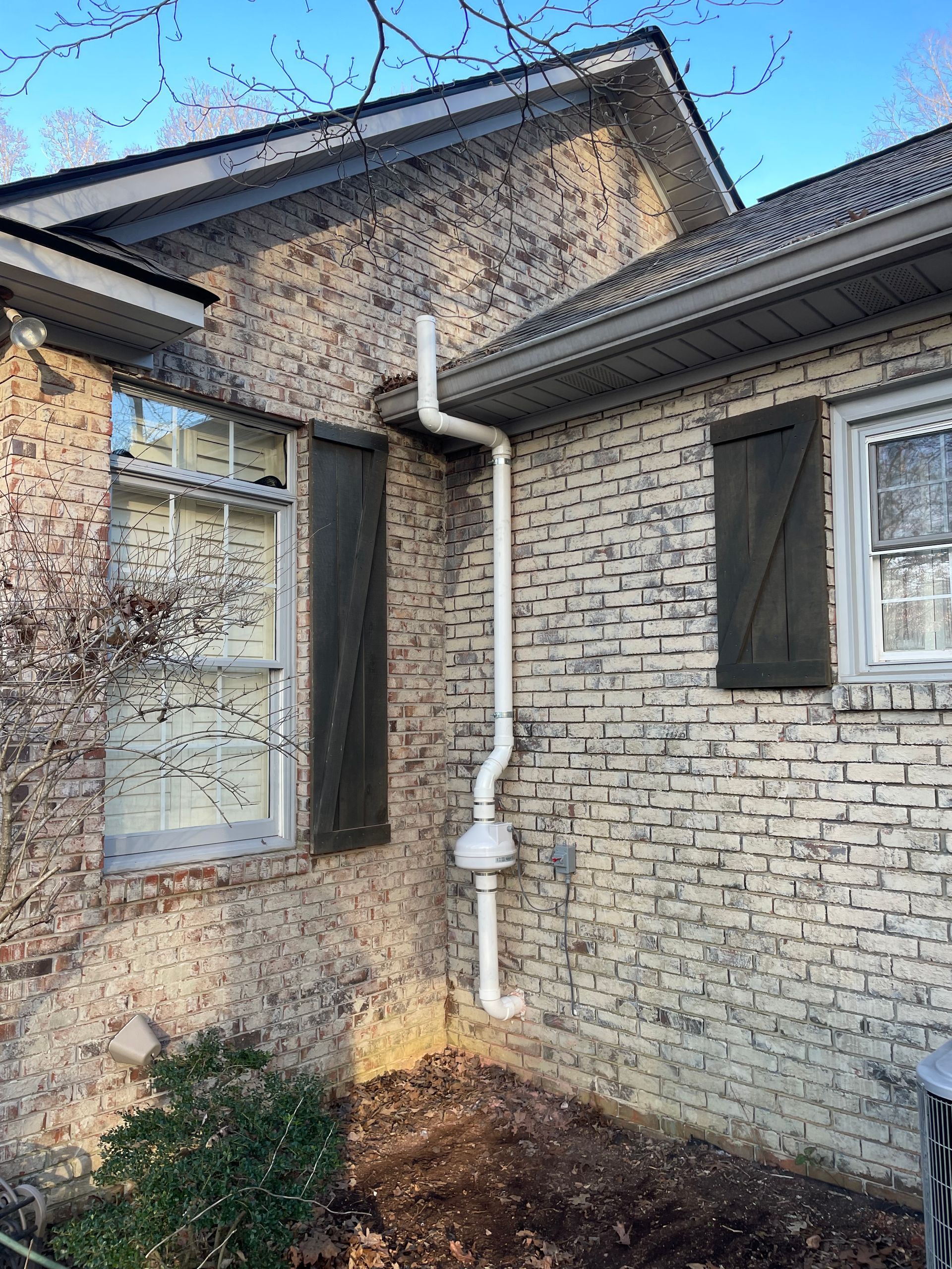 A White Pipe Is Attached to The Side of A Brick House | Birmingham, AL | Cardinal Construction