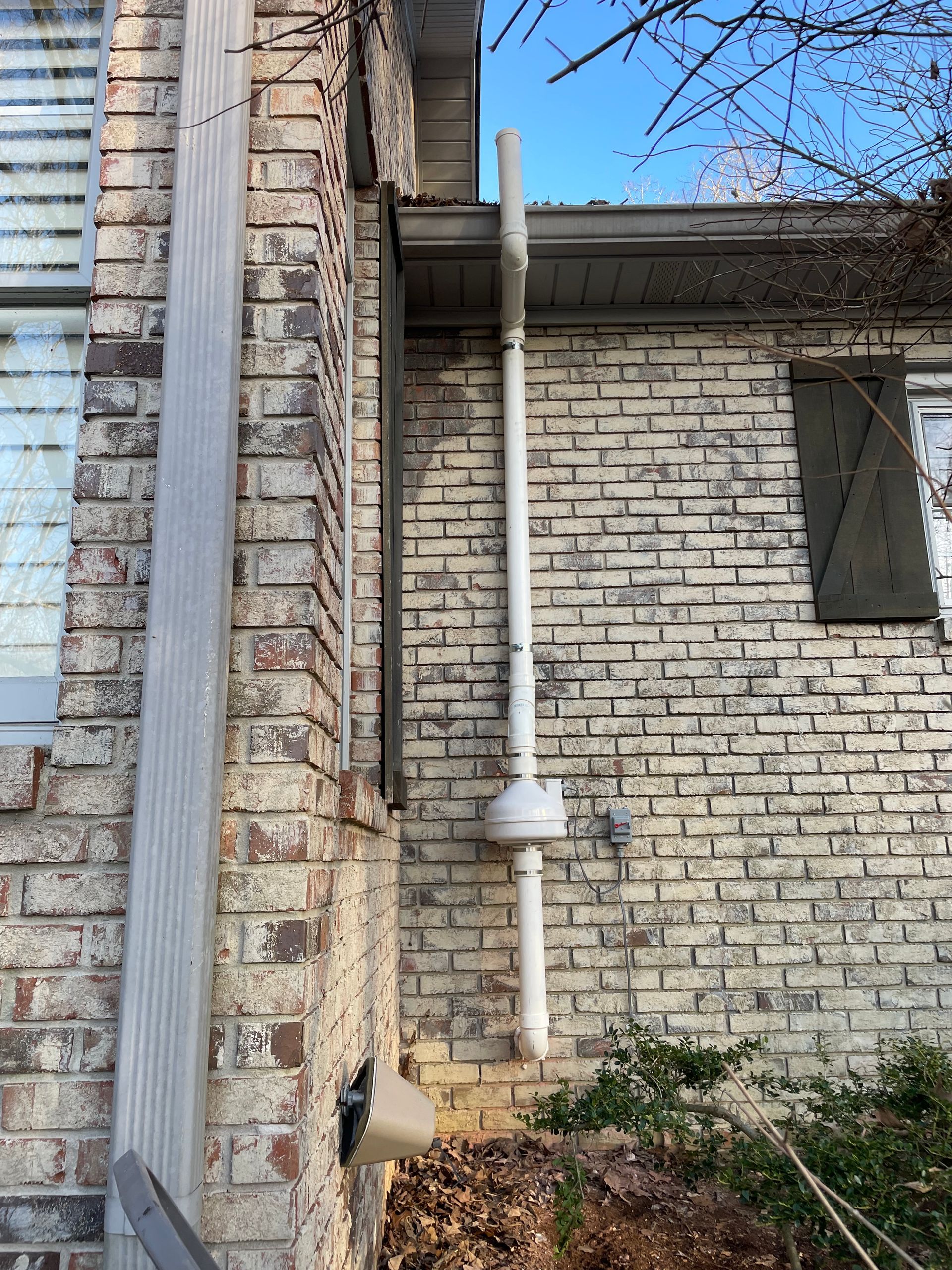 A White Pipe Is Attached to The Side of A Brick House | Birmingham, AL | Cardinal Construction