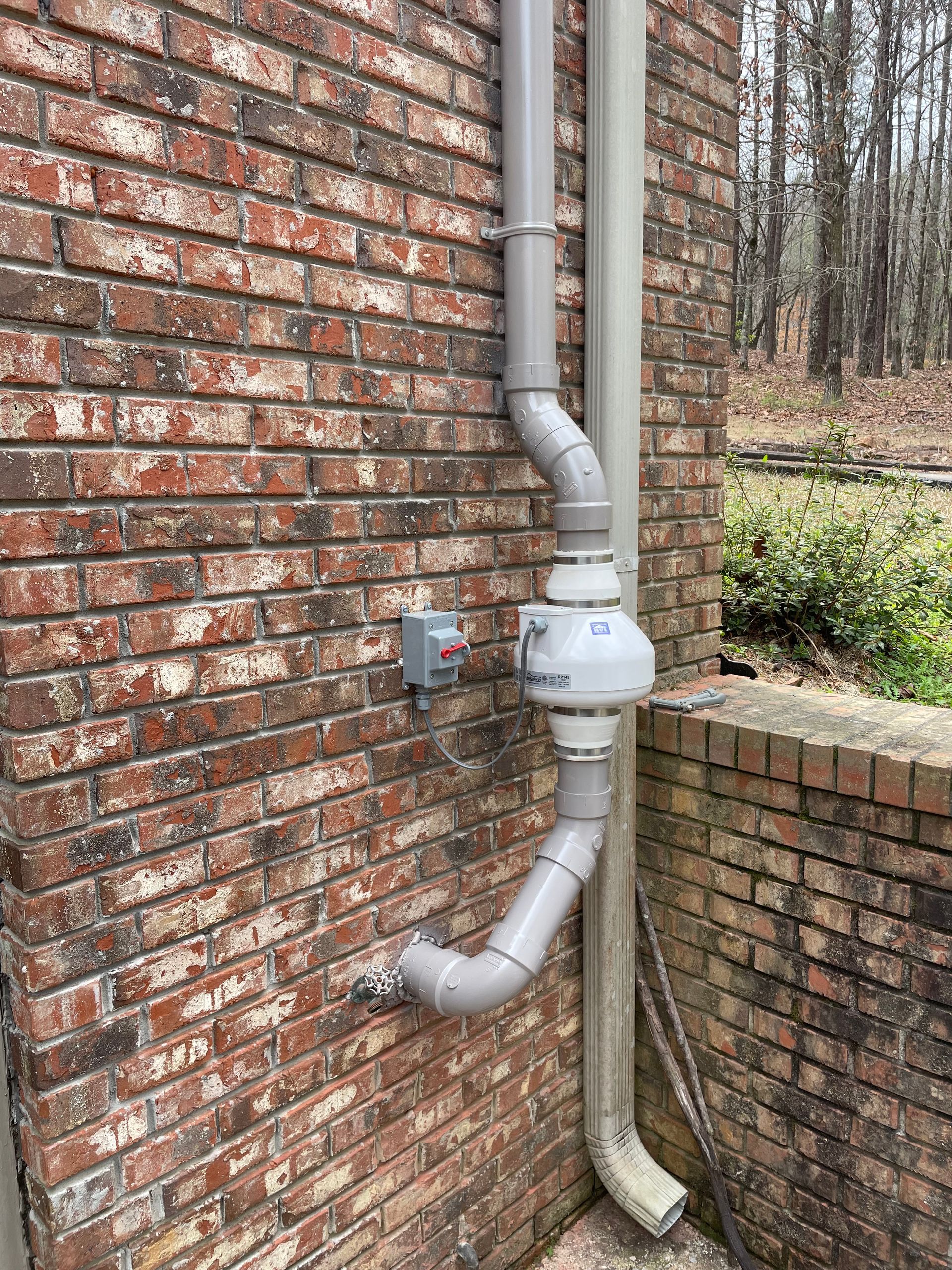 A Drain Pipe Is Attached to The Side of A Brick Building | Birmingham, AL | Cardinal Construction
