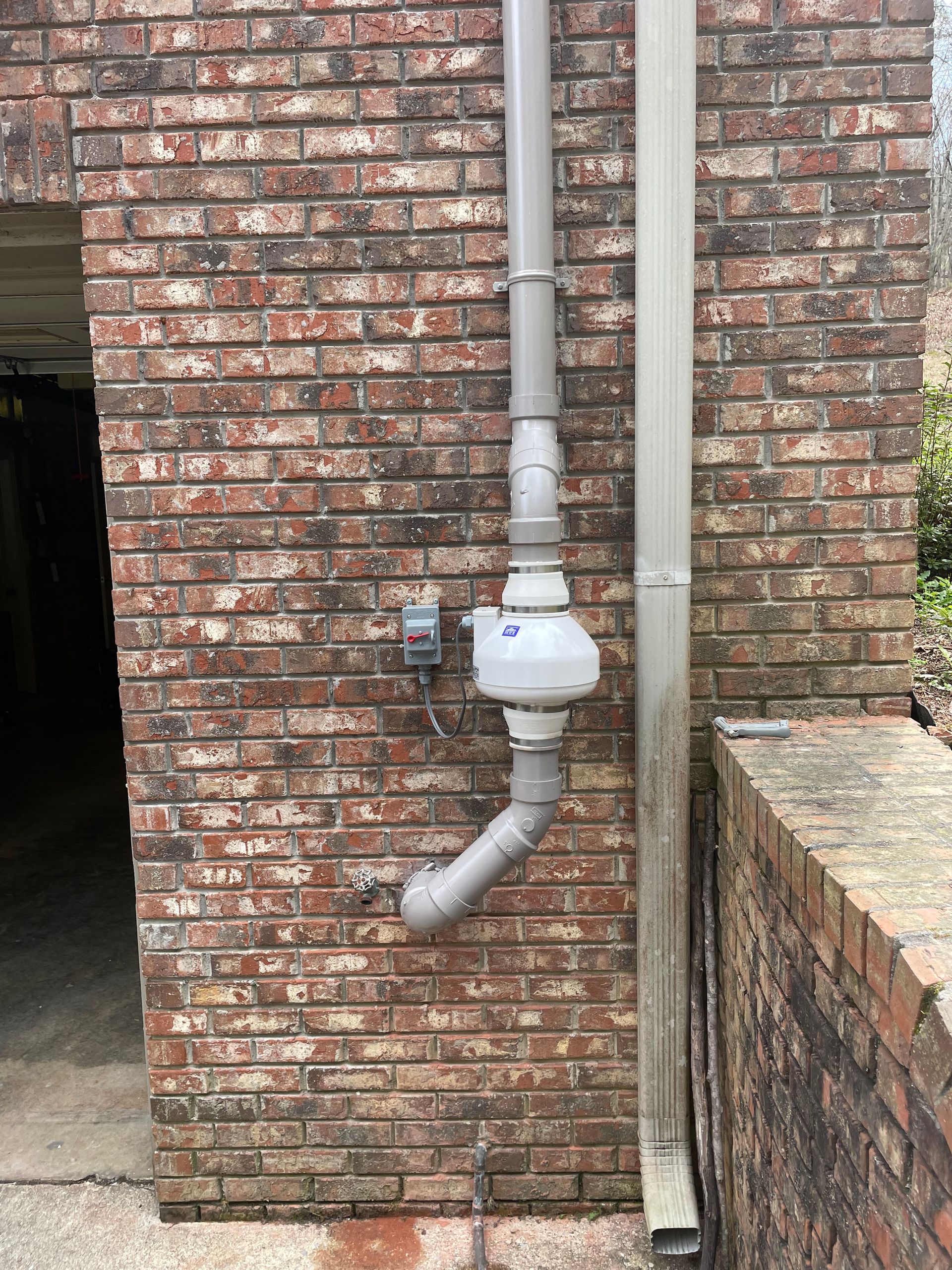 A Drain Pipe Is Attached to A Brick Wall | Birmingham, AL | Cardinal Construction