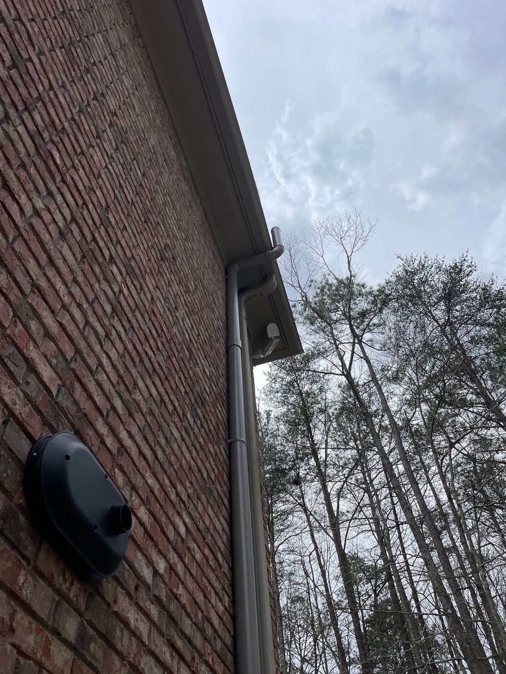 A Brick Building with A Gutter on The Side of It and Trees in The Background | Birmingham, AL | Cardinal Construction